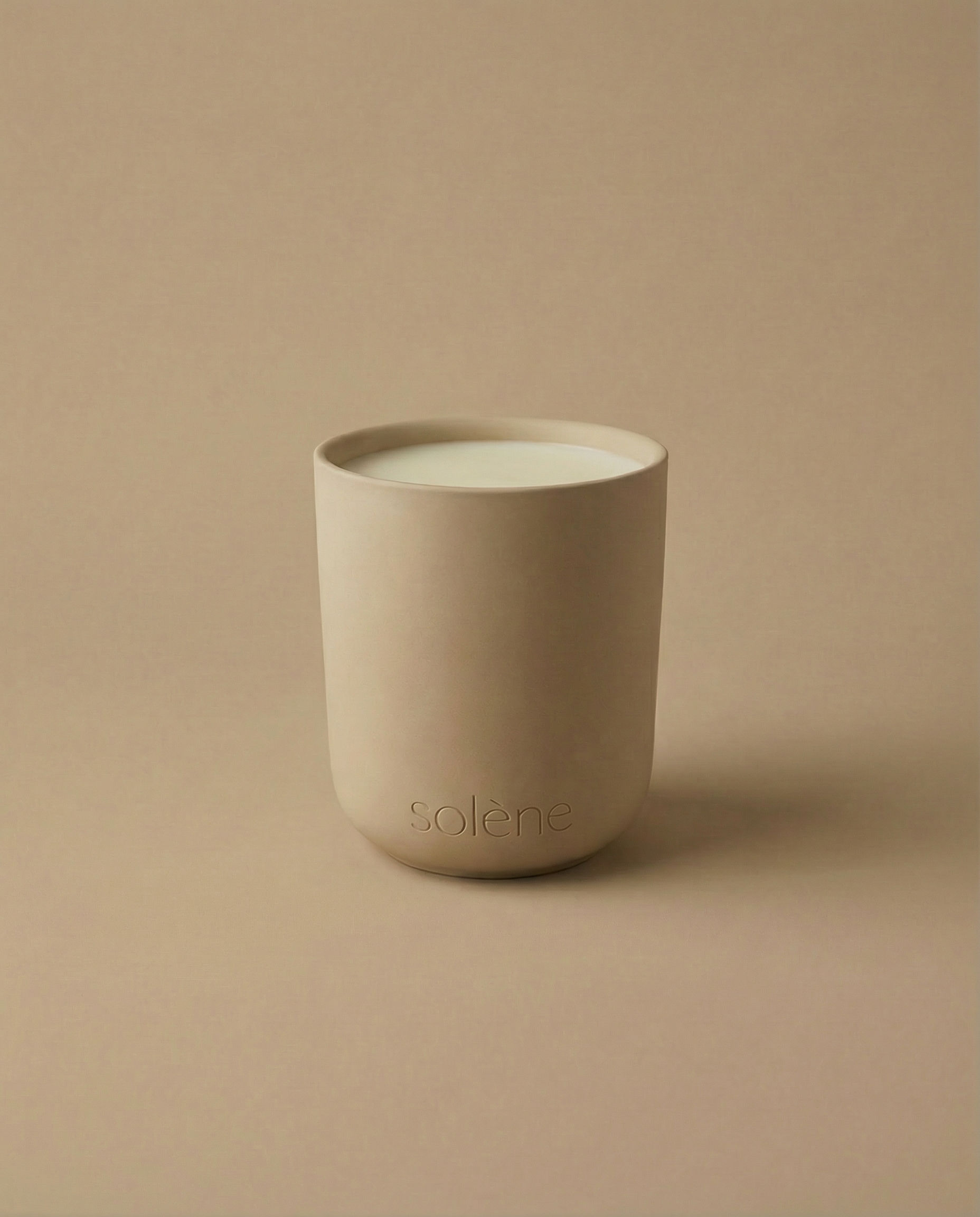 Monochromatic image of a beige Palo Santo and Sandalwood candle in a ceramic jar with 'Solene' branding on a beige background